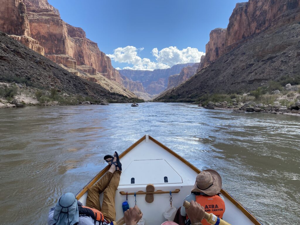 A boat with people on it in the middle of a river.